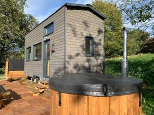 una casa pequeña con un barril delante de ella en Tiny House Lou Cabanot, en Goos