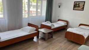 a room with three beds and a table in it at отель Voyage in Shymkent