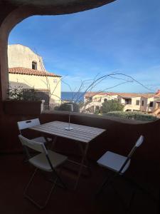 a table and chairs on a balcony with a table and a window at CASA VIOLA Two-room apartment with a sea view in La Marmorata