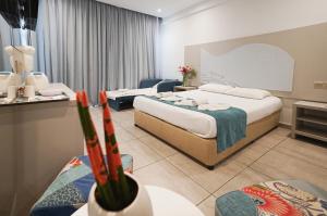a hotel room with two beds and a couch at Nicholas Color Hotel in Ayia Napa