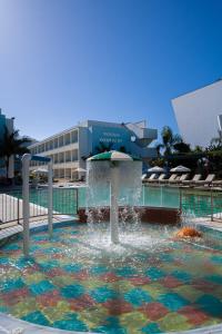 a fountain in a pool in front of a building at Nicholas Color Hotel in Ayia Napa +44 photos