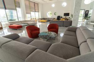a living room with a couch and red chairs at Nicholas Color Hotel in Ayia Napa