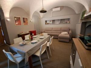 a living room with a table with chairs and a couch at La corte del Lago in Sulzano