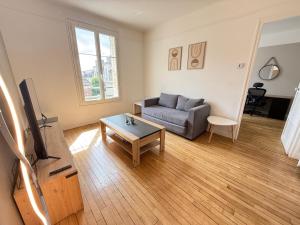 a living room with a couch and a table at Chez Rami - Charmant T3 - Rue Jacoby in Beauvais