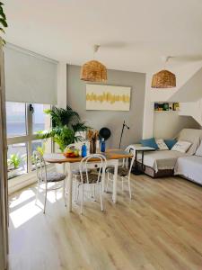 Una sala de estar con una mesa y sillas y un sofá. en Esti Chill & Stay, en Corralejo