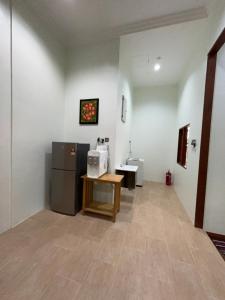 a room with a refrigerator and a table and a sink at Padimas Villa @Datai Valley in Teluk Datai