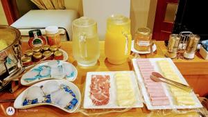a wooden table topped with plates of food and drinks at Hotel Piero in Villa Mercedes