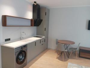 a kitchen with a washing machine and a table at Апартаменты в Батуми на берегу моря Mziuri Gardens in Batumi