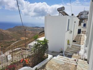 a white building with stairs and a view of the ocean at Sunshine House in Serifos Chora