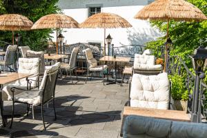 an outdoor patio with tables and chairs and umbrellas at ROESLI Guest House in Lucerne