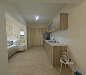 a kitchen with a sink and a couch in a room at Almyra in Finikounta