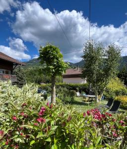 a garden with pink flowers in a yard at Appartement LAPRESKI, spacieux, proximité d'Annecy, les Aravis in Thônes