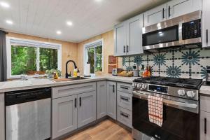 Una cocina con gabinetes blancos y un horno de estufa. en Sauk River Cabins - Hot tub - Firepit, en Darrington 26 fotos más