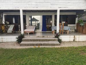 a porch of a house with a table and chairs at Blue Lagoon villa en bord de plage in Sainte Marie