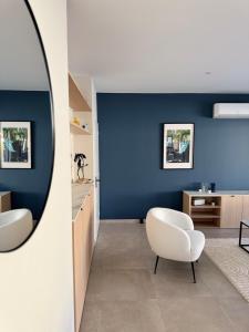 a room with a white chair and a blue wall at Villa haut de gamme Montauban in Montauban