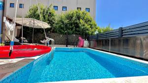 a swimming pool with a red boat and an umbrella at Apartman Stipić 2 in Kaštela