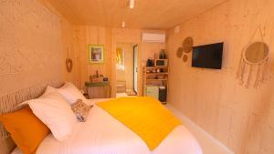a bedroom with a bed with a yellow blanket on it at DOUCE QUIETUDE chambre d'hôtes in Vals-les-Bains
