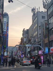 a busy city street with cars and people crossing the street at LibeStay in Busan