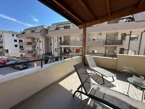 balkon z krzesłem i stołem oraz budynek w obiekcie Zeta Rooms w mieście Caserta