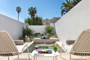 a bird sitting on a table on a patio with two chairs at Pazziella Garden & Suites in Capri