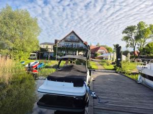 Łódź zacumowana jest przed domem. w obiekcie Pensjonat Rybaczówka - noclegi, restauracja, port w mieście Giżycko