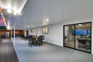 a dining room with tables and chairs and windows at Sleeps 31 10br Mountain View, Pool, Spa and Games in El Cajon