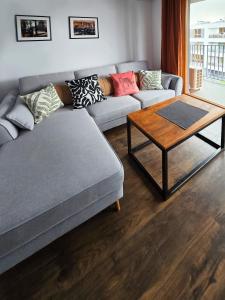 a living room with a couch and a coffee table at Schindler’s Factory Zabłocie Deluxe Apartments WAWELOFTS in Kraków