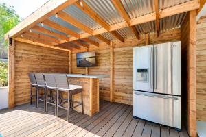 a kitchen with a refrigerator and a bar on a deck at Sleeps 31 10br Mountain View, Pool, Spa and Games in El Cajon