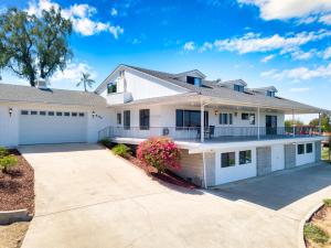 a large white house with a driveway at Sleeps 31 10br Mountain View, Pool, Spa and Games in El Cajon