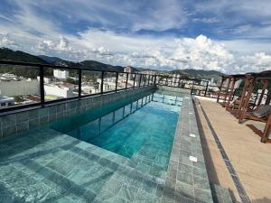 a swimming pool on the roof of a building at Flat Diamond São Lourenço TOP 308 MG in São Lourenço