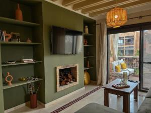 マラケシュにあるPeaceful 2BR Oasis with Pool Tennis AC - Palmeraieのリビングルーム(暖炉、薄型テレビ付)