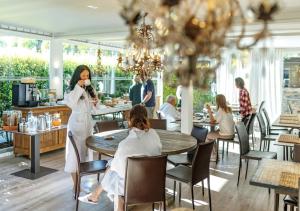 una mujer sentada en una mesa en un restaurante en Sierra Blanca Resort Art of Healing, en Marbella 36 fotos más
