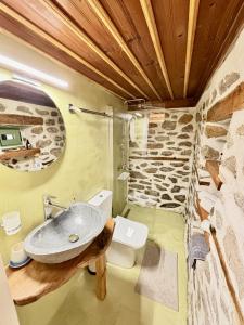 a bathroom with a sink and a stone wall at Atelies View House in Potamiá +34 photos