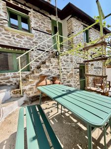 a picnic table in front of a stone house at Atelies View House in Potamiá