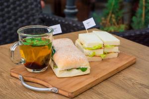 a sandwich cut in half next to a cup of tea at Hotel Vasudevay Inn in Haridwār