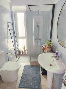 a bathroom with a white toilet and a sink at Nel Blu - Seaside Apartment in Saronida