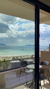 a view of the beach from a balcony with a table and chairs at Seamare Studio & Apartaments in Vlorë