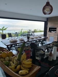 een bos bananen en andere vruchten op een tafel bij Maluhia Ilhabela 1 in Ilhabela