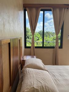 a bedroom with two beds and a large window at Otoch Maya in Valladolid