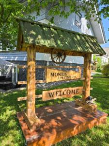a wooden structure with a welcome sign in the grass at Montis Bled in Bled