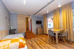 a bedroom with a bed and a desk and a table at Gościniec Pod Markizami in Malbork