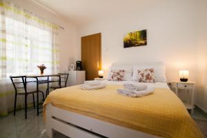 a bedroom with a bed with two towels on it at Old Town Accommodation in Bol
