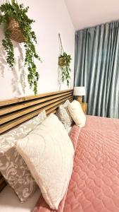 a bedroom with a pink bed with pillows on it at Atlantico Flamingo in Calpe