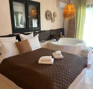 a bedroom with a large bed and a bath tub at Kynthia Hotel - Adults Only in Kalogria