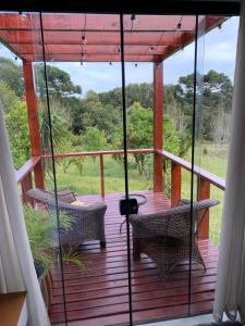 a porch with two chairs and a table on it at Containerhaus in Carlos Barbosa