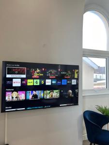 a flat screen tv hanging on a wall at Welsh Getaway Apartment - Town Centre in Merthyr Tydfil