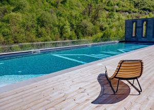 a chair sitting on a deck next to a swimming pool at Dilijan Inn Hotel and Restaurant in Dilijan