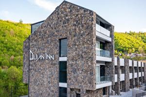 a stone building with a sign on it at Dilijan Inn Hotel and Restaurant in Dilijan