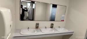 een persoon die een foto neemt van twee wastafels in een badkamer bij Love Boat Hostel in Lissabon