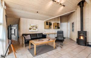 a living room with a couch and a fireplace at Holiday Home Sivsangervænget Tarm in Hemmet